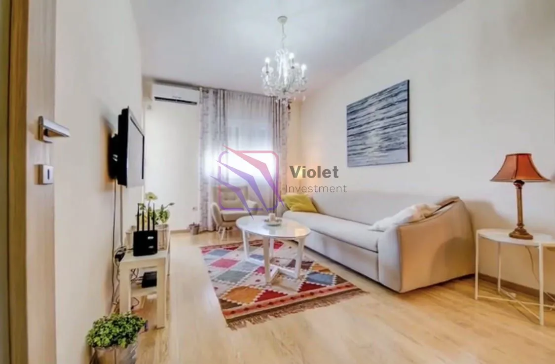 Living room with a sofa, coffee table, TV and decorative lighting.