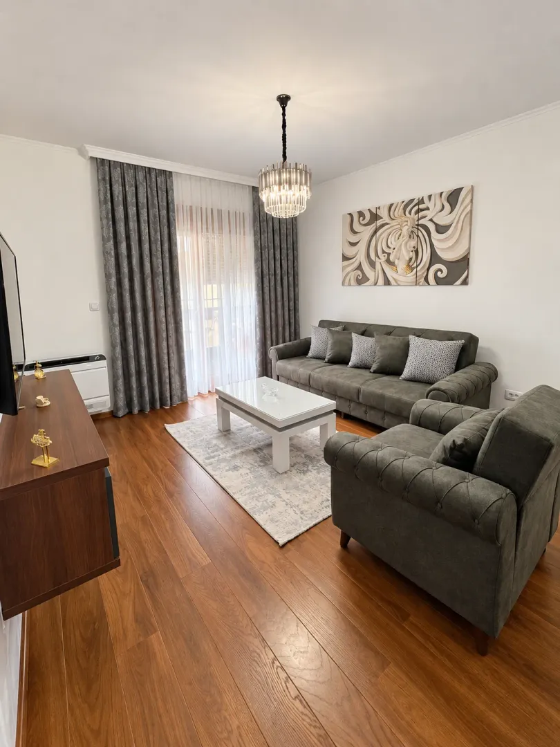 Furnished living room with sofa set, coffee table, and TV unit.