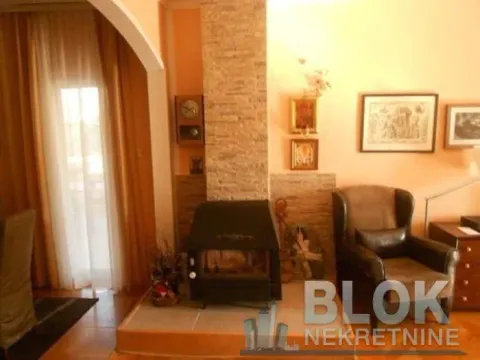 Living room with a fireplace and an armchair. - image 2