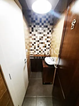 Small bathroom with a washbasin and brown-toned tiles. - image 4