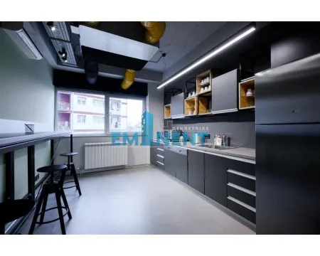 Modern dark-toned kitchen with a counter and bar stools. - image 15