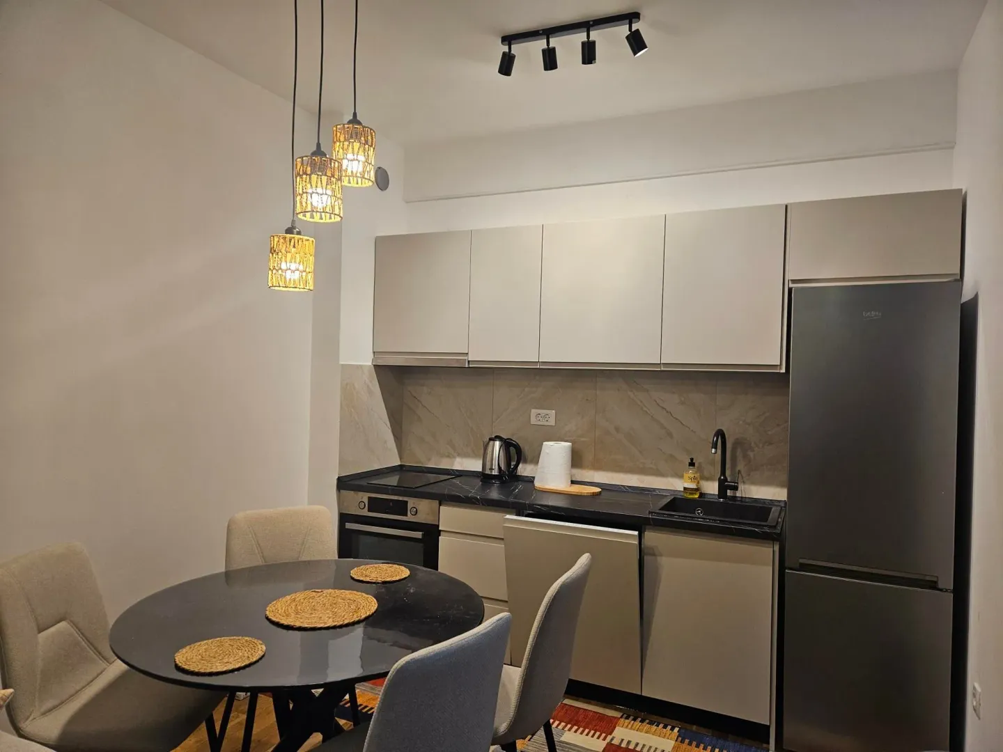 Modern kitchen with dining table and built-in appliances.