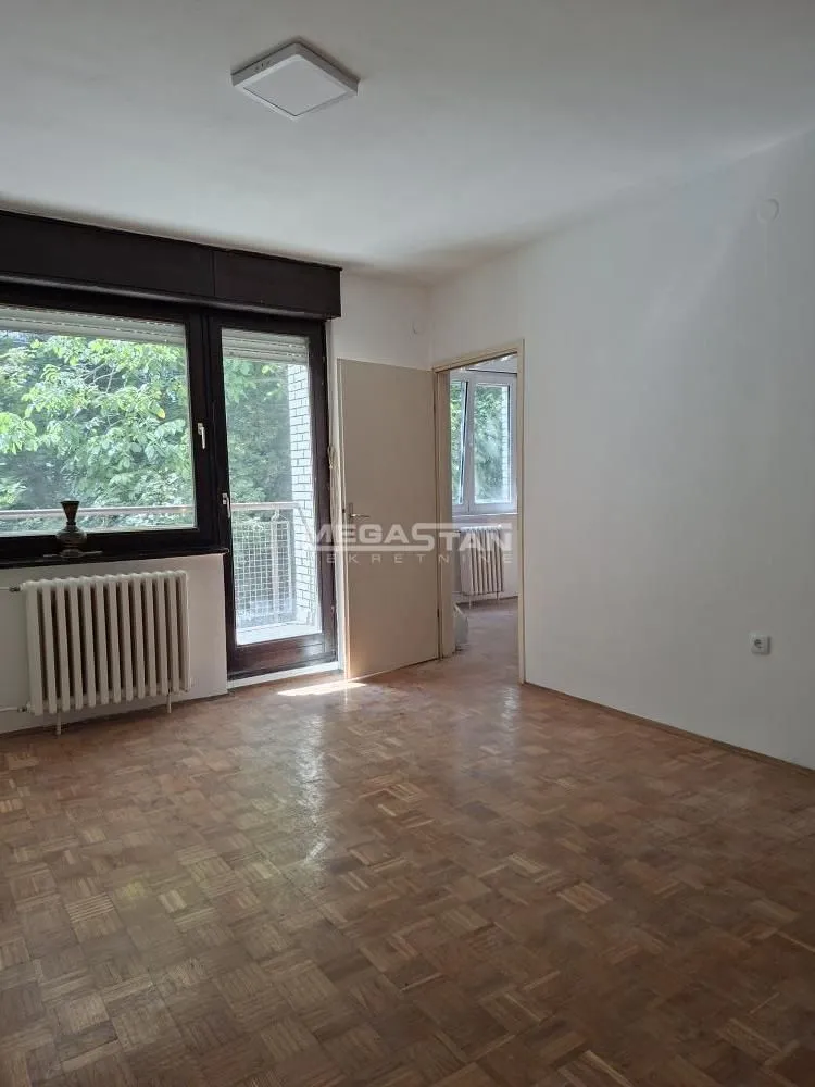 Empty room with parquet flooring and access to a terrace.