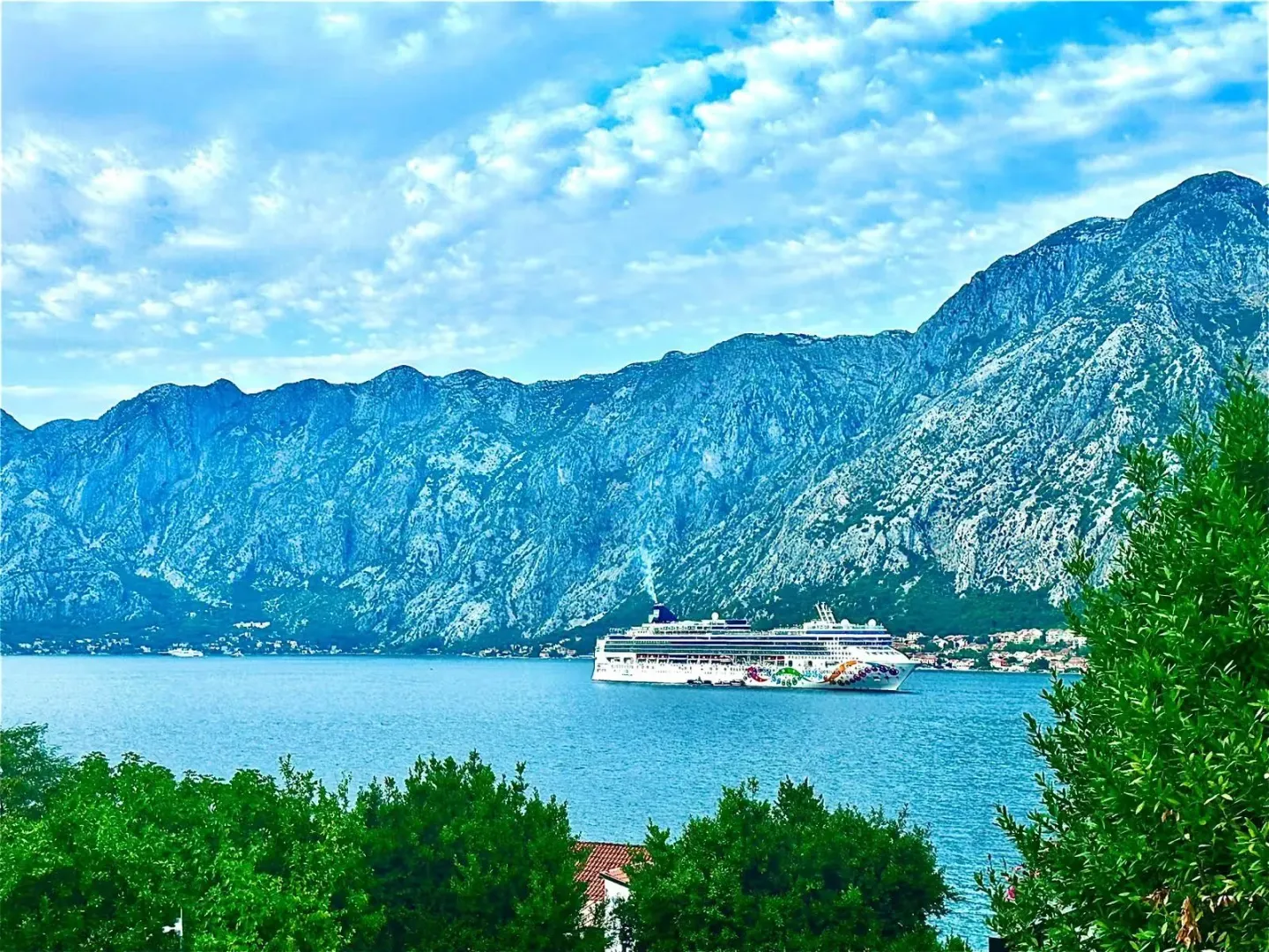 Pogled na more i planine sa kruzerom u zalivu.