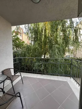 Popločana terasa sa stolicama i pogledom na drveće. - image 7