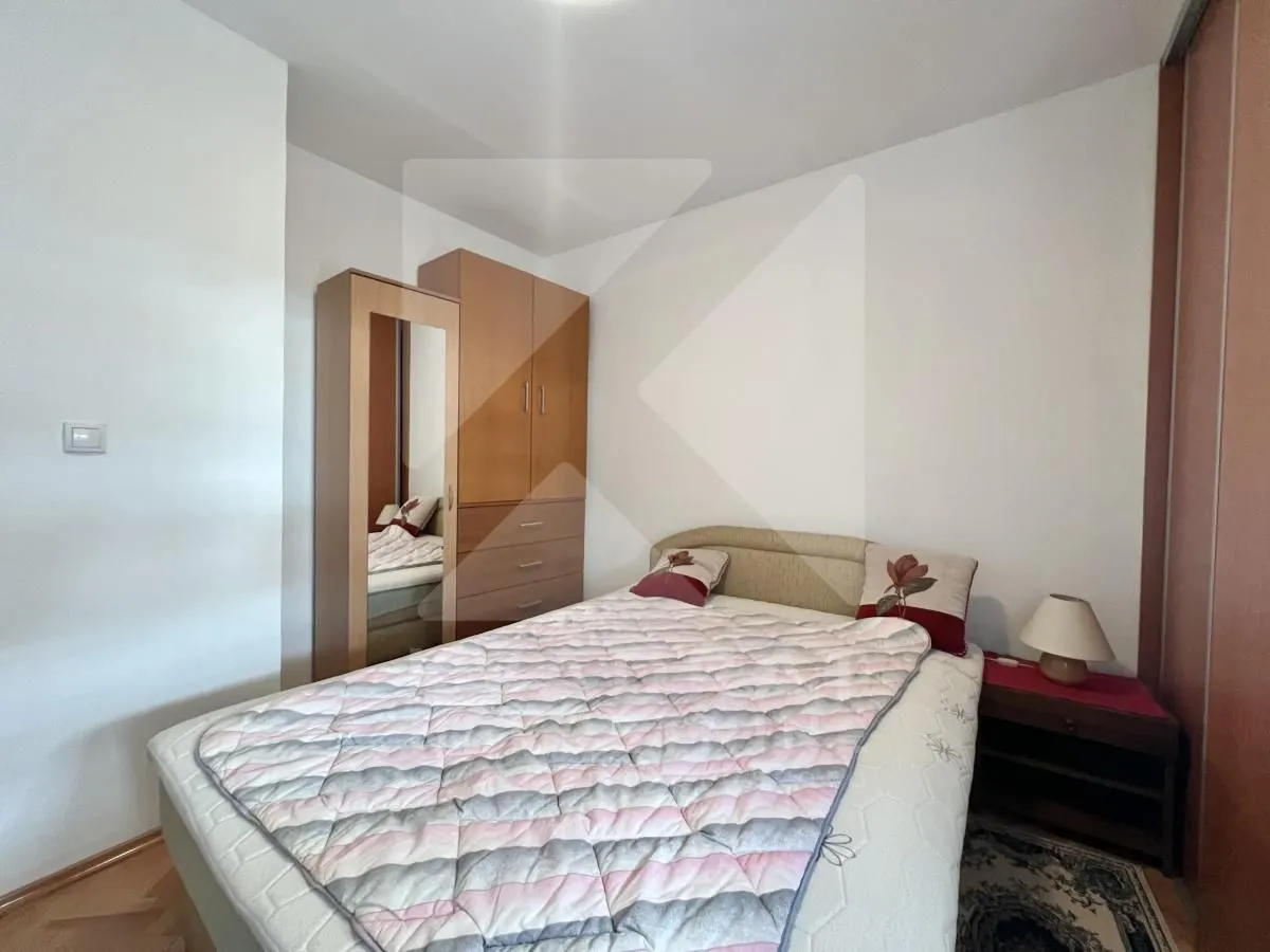 Furnished bedroom with a double bed, wardrobe, and a nightstand.