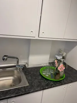 A section of a kitchen featuring a sink and white cabinets. - image 20
