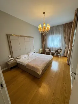 Prostrana spavaća soba sa bračnim krevetom, drvenim podom i velikim prozorom. - image 12