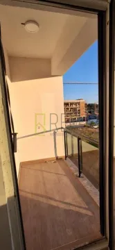 Manji nenamješten balkon sa drvenim podom i pogledom na okolne zgrade. - image 8