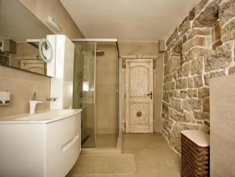 Modern bathroom with a shower cabin and a stone wall. - image 6