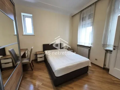Furnished bedroom with a double bed, wardrobe, and a desk. - image 8