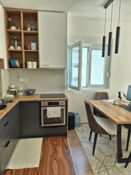 Modern kitchen with built-in appliances and a dining table. - image 4