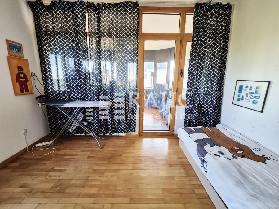 Furnished bedroom with a bed and wooden floor.