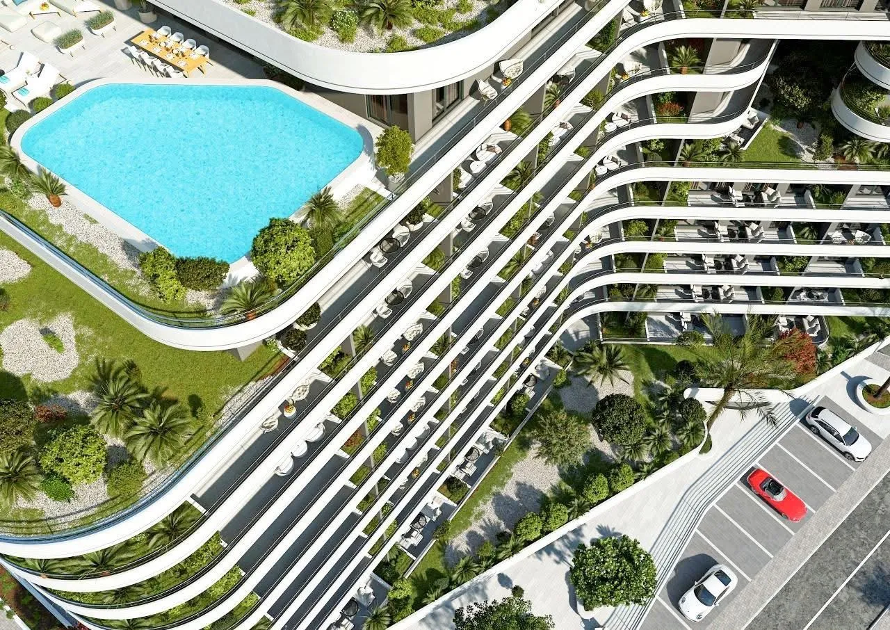 Aerial view of a modern residential building with a swimming pool and terraces.