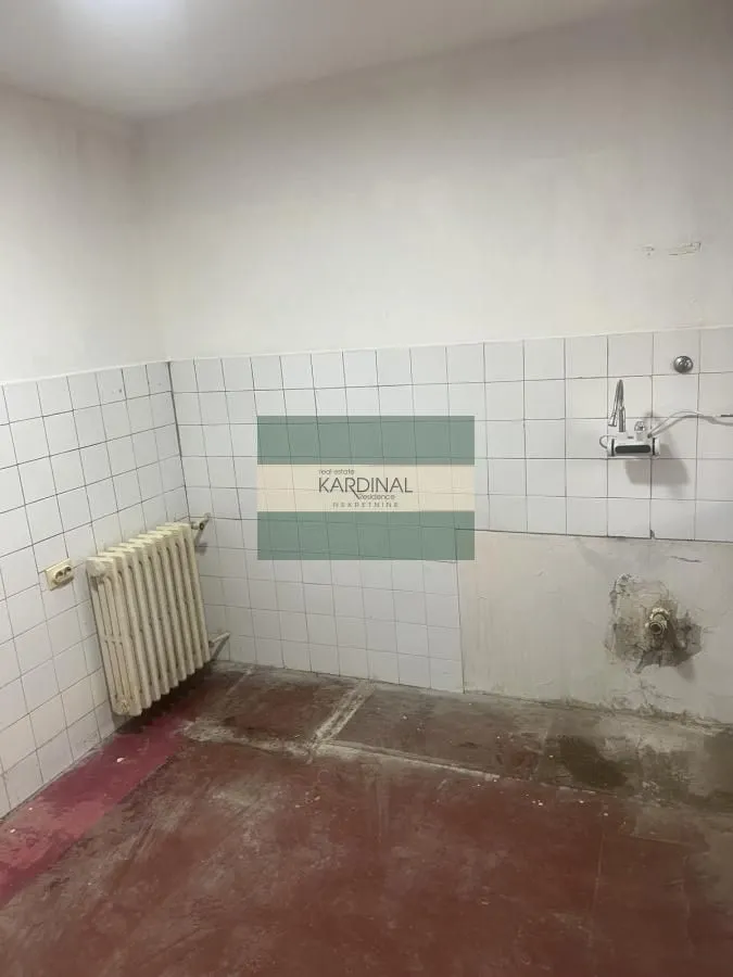 Starija kuhinja za renoviranje sa keramičkim pločicama i radijatorom.