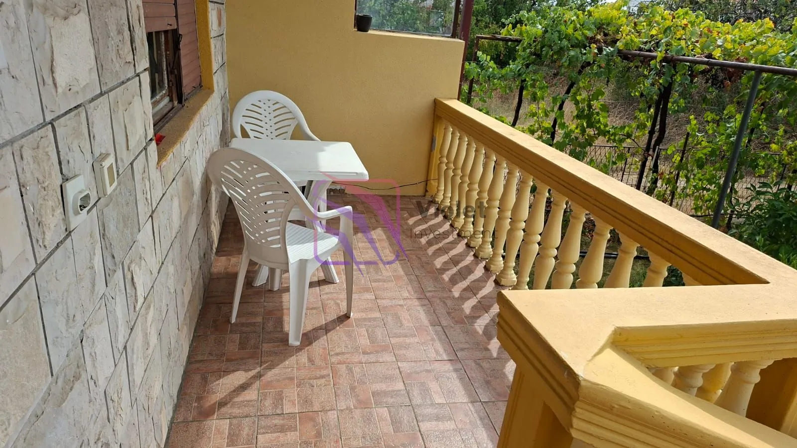 Covered balcony with patio furniture and a view of the yard.