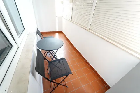 Uski balkon sa pločicama, malim okruglim stolom i dvije stolice. - image 25