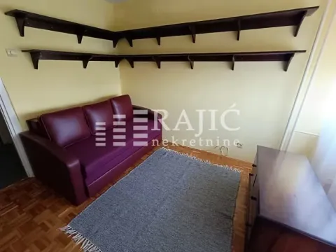 Living room with a sofa, shelves, and a rug. - image 6