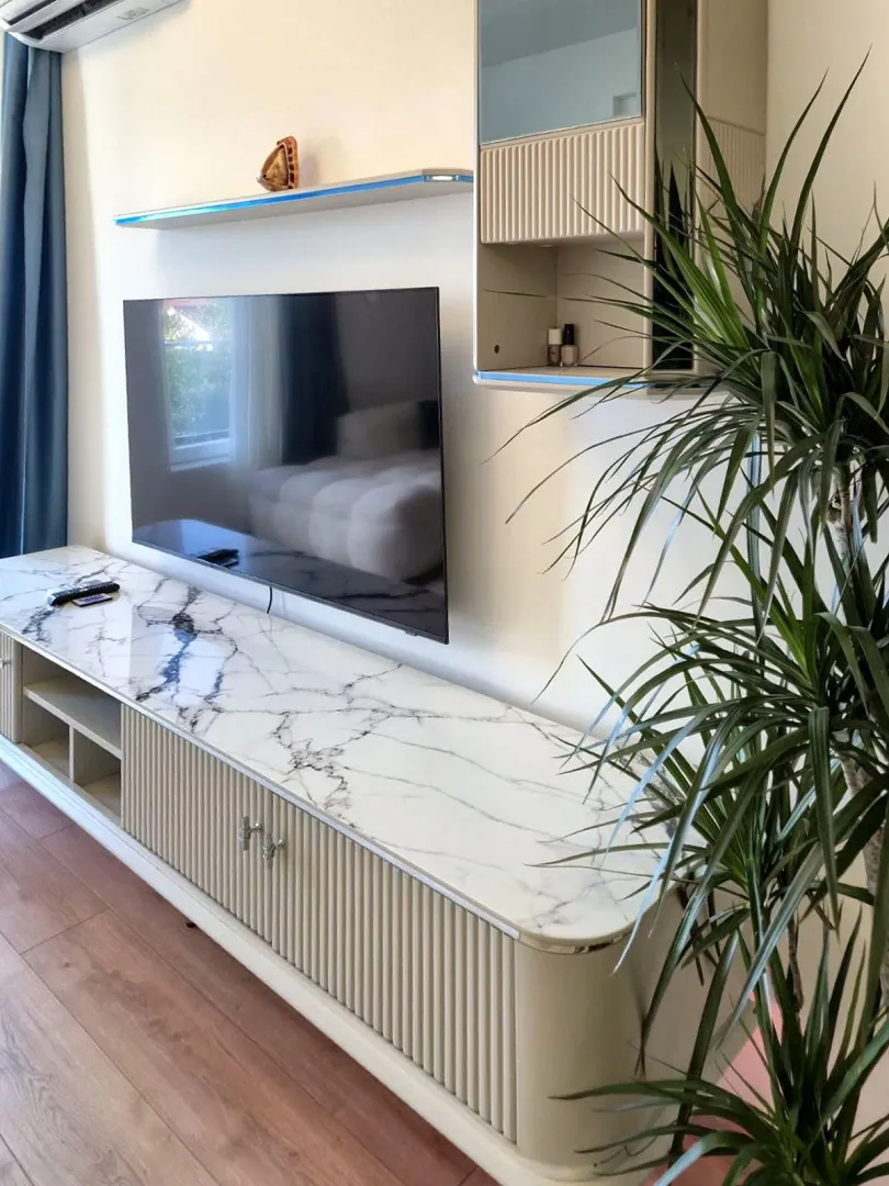 Dnevna soba sa televizorom i modernom komodom.
