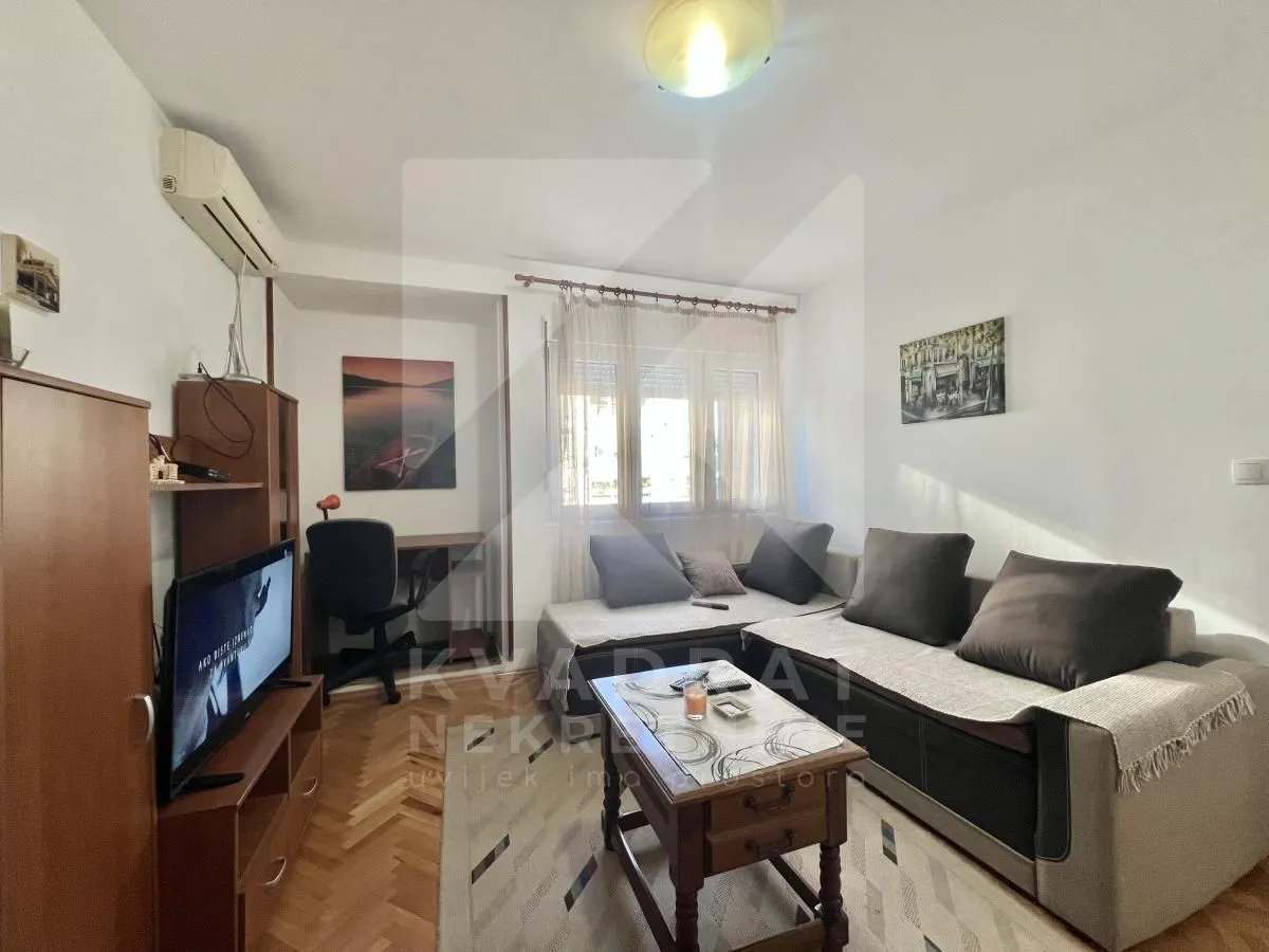 Living room with a sofa set, television, and a desk.