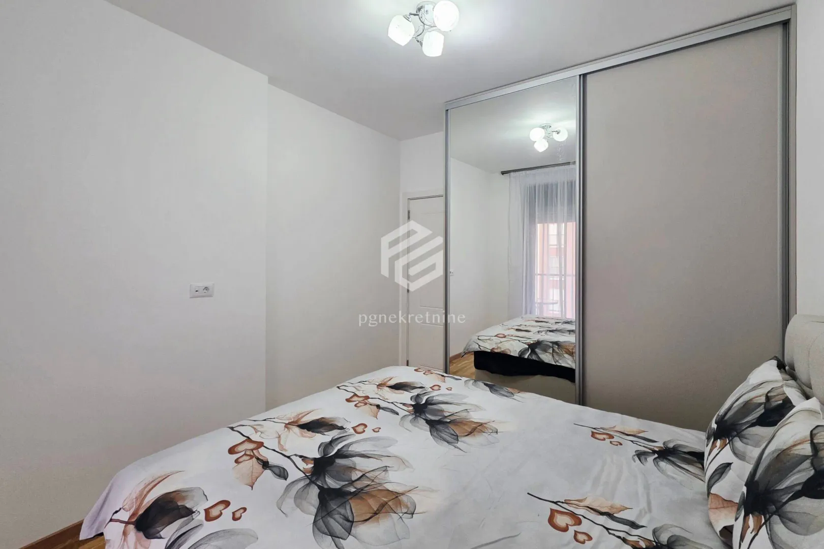 Bedroom with a double bed and a fitted wardrobe with a mirror.