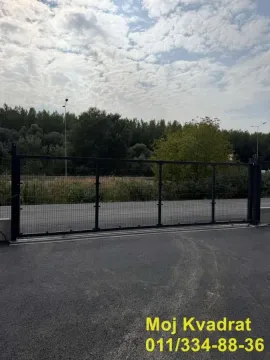 View of the metal gate and courtyard with an asphalt driveway. - image 3