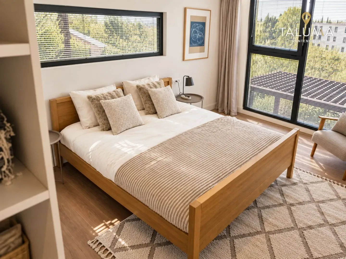 Bright bedroom with a large double bed and a view of greenery.