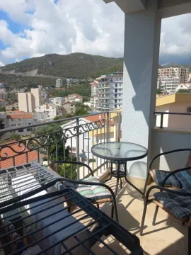 Namještena terasa sa stolom i stolicama i pogledom na grad i planine. - image 9