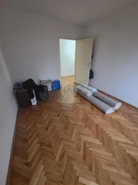 Prazna prostorija sa parketom i smotanim tepisima na podu. - image 6