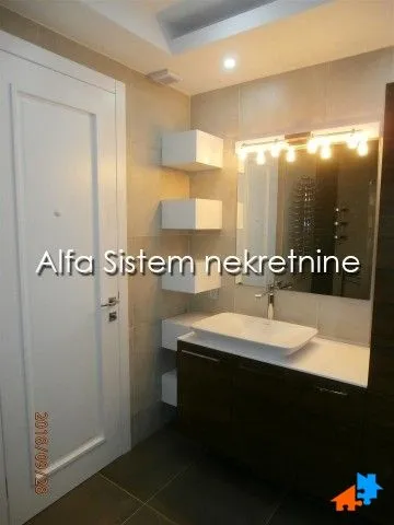 Modern bathroom with a washbasin, mirror and white door.