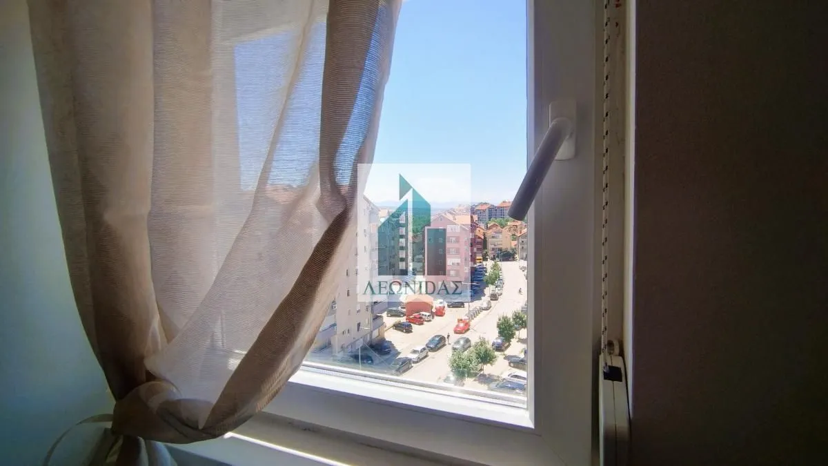 View through the window onto surrounding buildings and the street.