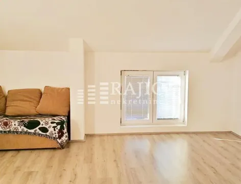 Living room with laminate flooring and a couch. - image 2