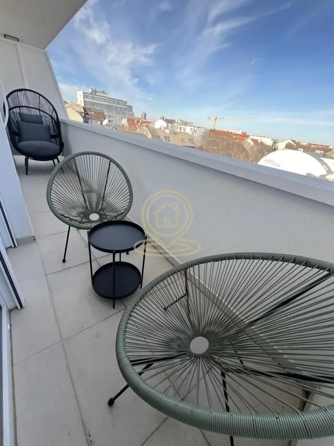 Namešten balkon sa garniturom za sedenje i pogledom na grad.