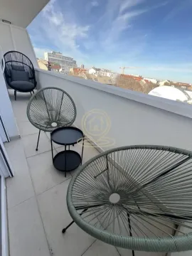 Namešten balkon sa garniturom za sedenje i pogledom na grad. - image 13