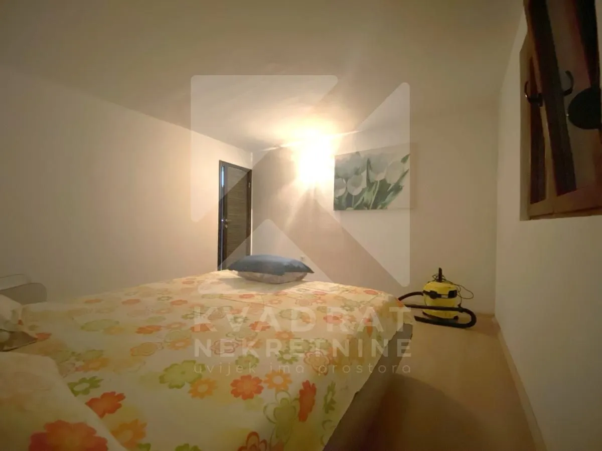 Furnished bedroom with a double bed and a painting on the wall.