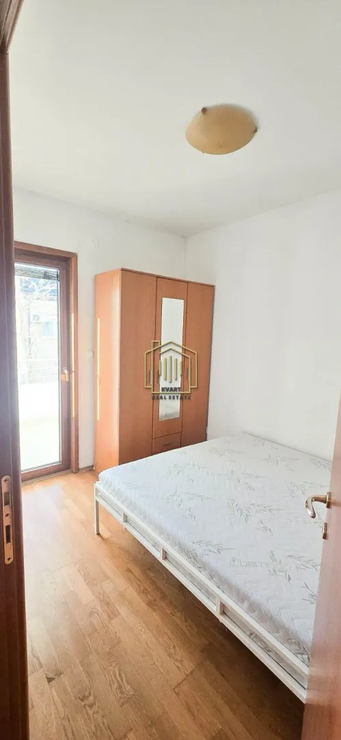 Small bedroom with a bed, wooden wardrobe, and access to the terrace.