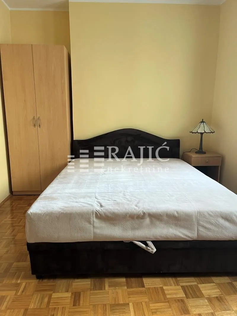 Furnished bedroom with a double bed, wardrobe, and nightstand.