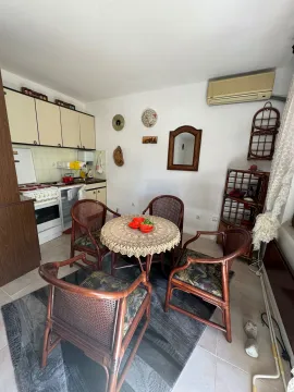 Small kitchen with a dining table and wooden chairs. - image 3