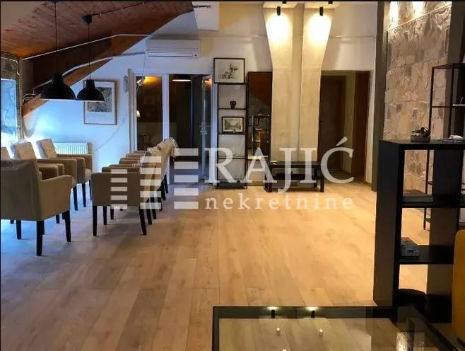 Spacious living room with wooden flooring and seating furniture.