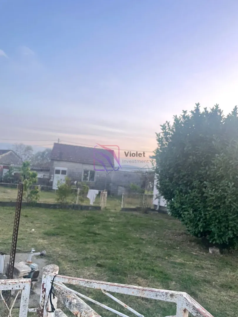 Pogled na dvorište i okolne objekte sa travnjakom.