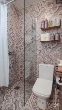 Kupatilo sa tuš kabinom i wc šoljom obloženo dekorativnim pločicama. - image 15