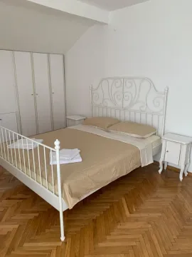 Bright bedroom featuring a white metal bed frame and parquet flooring. - image 19