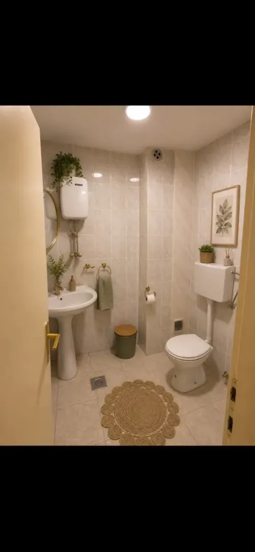 Small bathroom with a sink, toilet, and tiled walls.