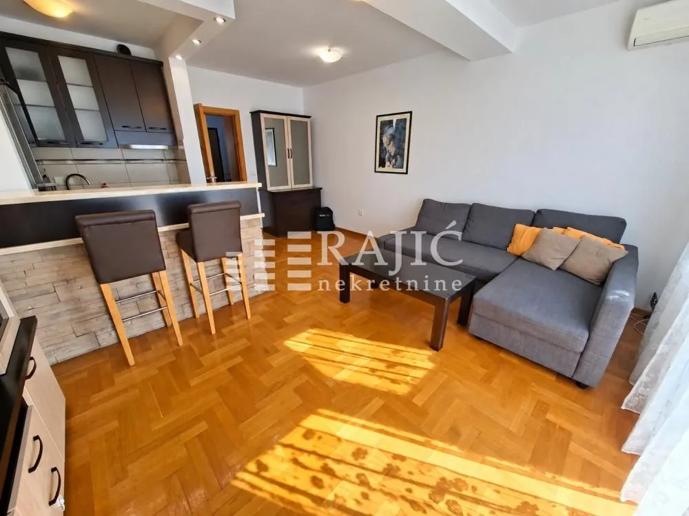 Living room with a sofa connected to the dining area and kitchen.