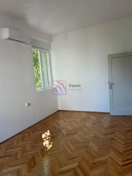 Prazna soba sa parketom, prozorom i klima uređajem. - image 2