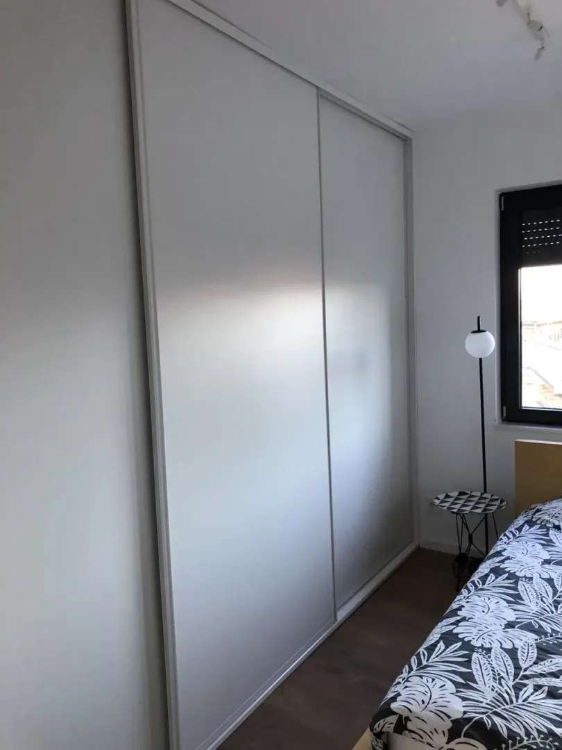 Bedroom with a large built-in wardrobe and a bed.