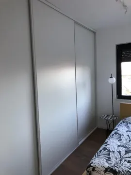 Bedroom with a large built-in wardrobe and a bed. - image 9