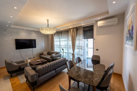 Living room with a sofa set, television, and dining table. - image 2