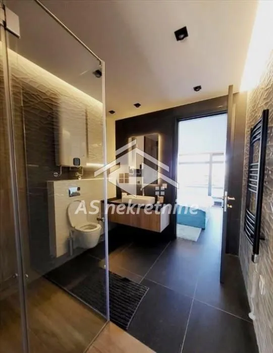 Modern bathroom with a shower cabin, washbasin, and toilet.
