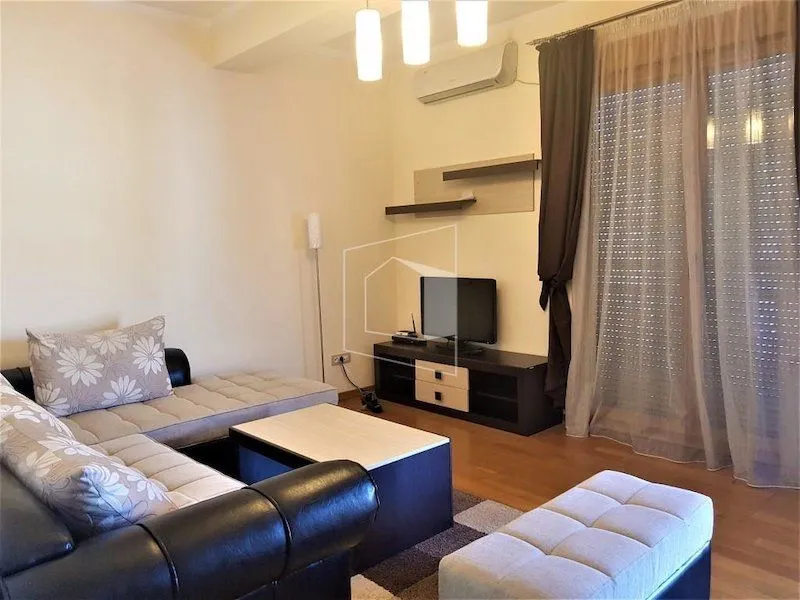 Dnevna soba sa garniturom, stočićem i TV komodom.